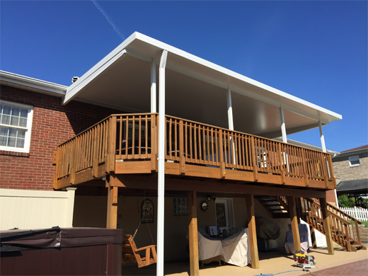 A wooden deck with a white awning over it.