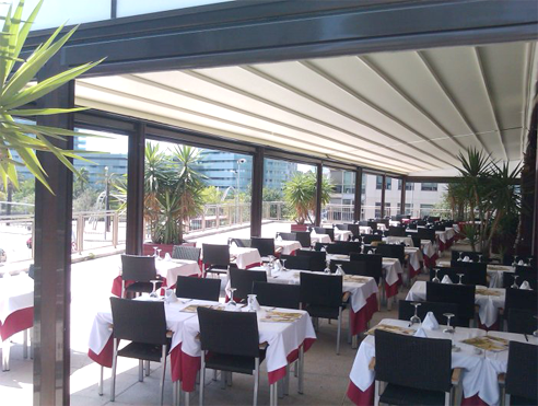 A restaurant with tables and chairs set up for dinner.