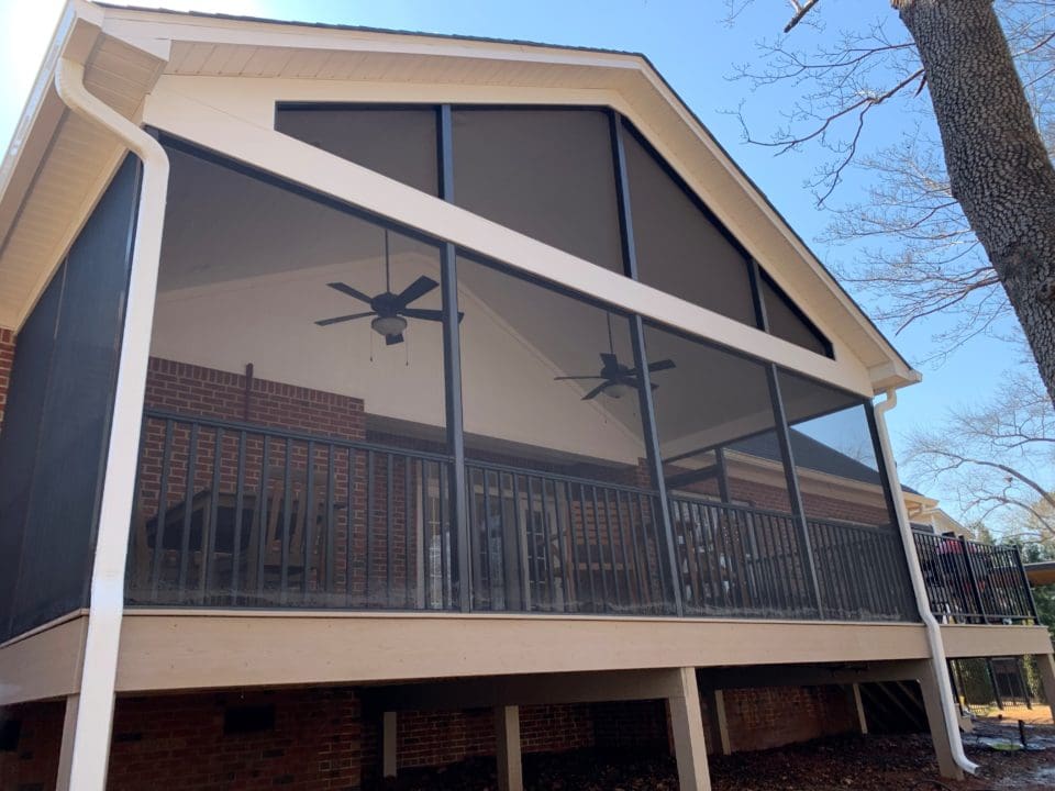 A large screen porch with a ceiling fan.