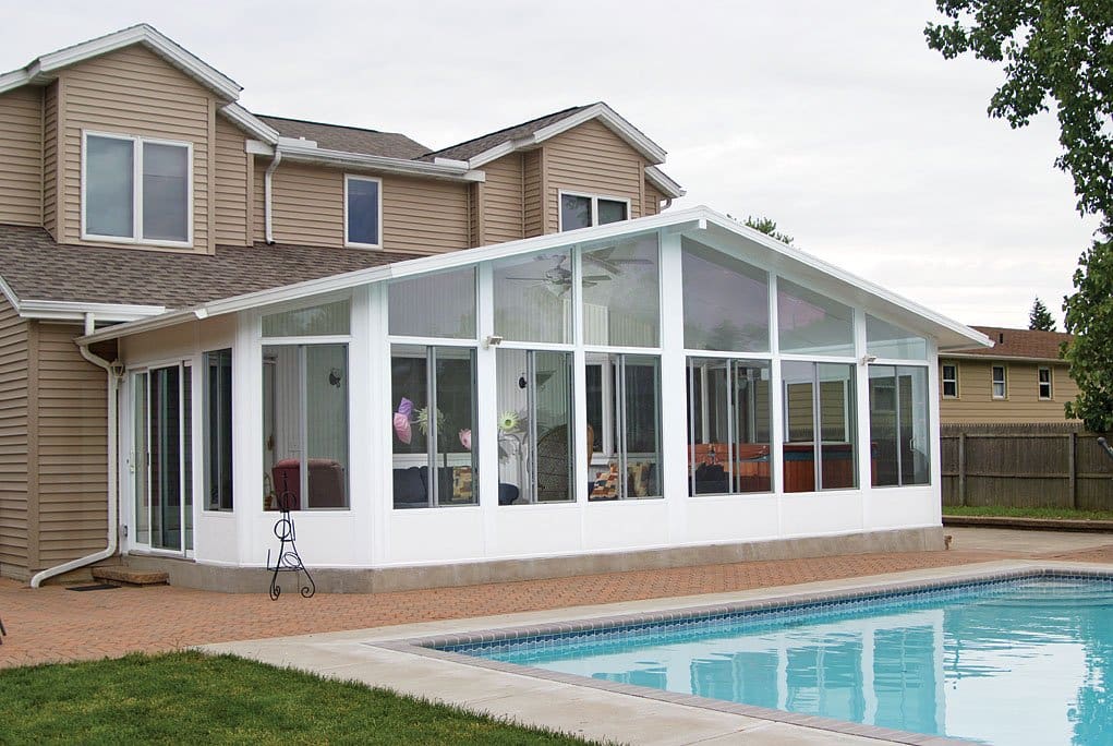 A large white sunroom next to the pool.